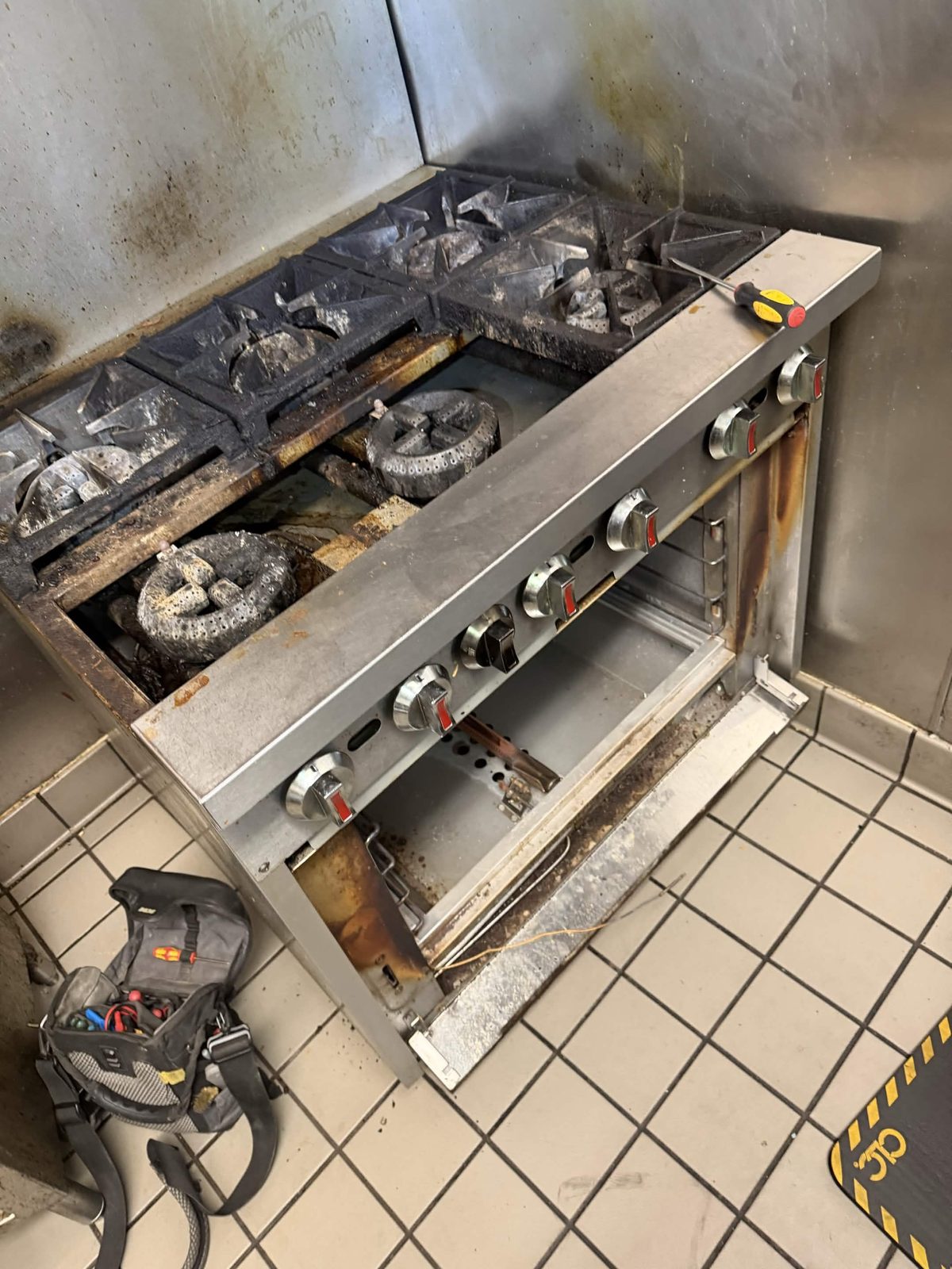 Commercial gas range opened for burner repair