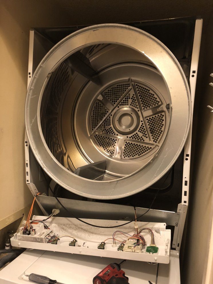 Dryer opened with the drum exposed for repair